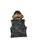 A sleeveless camouflage hooded vest with a brown faux-fur trimmed hood and silver zipper details, laid flat on a textured gray background.